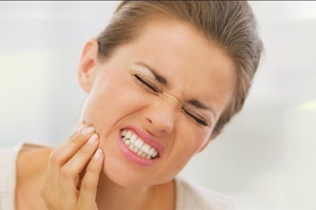 Woman holding her mouth in pain